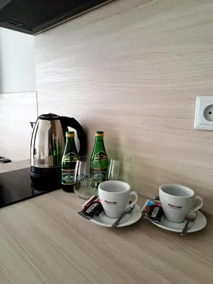 two coffee cups and wine glasses on a counter at Sympo Apartments in Kraków