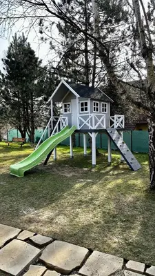 a playground with a slide and a play house at Sękata Chata - drewniany domek z jacuzzi in Osieczany