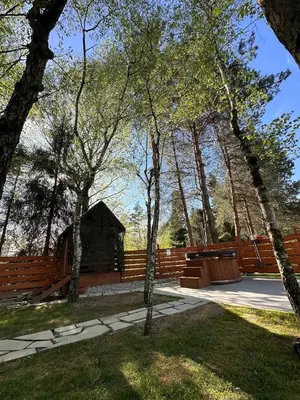 a park with a bench and a wooden fence at Sękata Chata - drewniany domek z jacuzzi in Osieczany