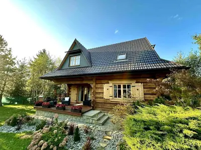 a log cabin with a gambrel roof at Sękata Chata - drewniany domek z jacuzzi in Osieczany