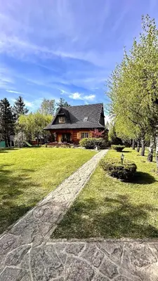 a house with a stone path in front of a house at Sękata Chata - drewniany domek z jacuzzi in Osieczany