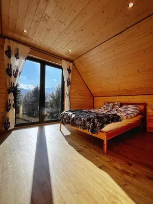 a bedroom with a bed and a large window at Zawojska Kapryśnica Zawoja Górna 2970 in Zawoja