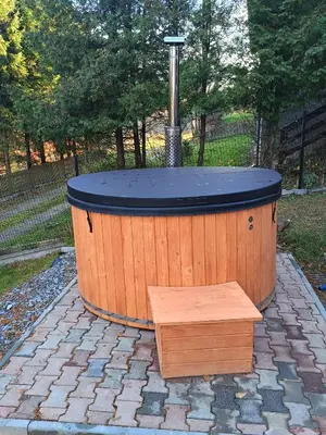 a large wooden tub with a bench in a backyard at Zawojska Kapryśnica Zawoja Górna 2970 in Zawoja
