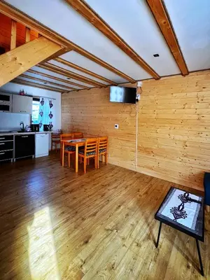 a living room with a table and a kitchen at Zawojska Kapryśnica Zawoja Górna 2970 in Zawoja