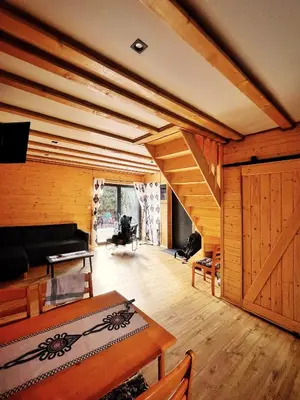 a living room with wooden walls and a wooden stairs at Zawojska Kapryśnica Zawoja Górna 2970 in Zawoja