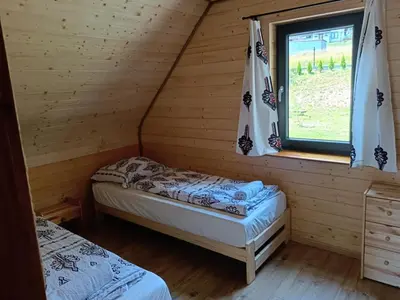 two beds in a log cabin with a window at Zawojska Kapryśnica Zawoja Górna 2970 in Zawoja