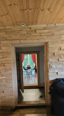 a room with a wooden wall with a doorway at Chałupa na Wierzchowinie in Limanowa