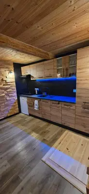a room with wooden ceilings and a blue counter top at Chałupa na Wierzchowinie in Limanowa