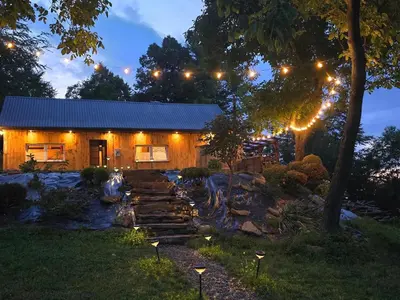 a house with lights in the yard at night at Chałupa na Wierzchowinie in Limanowa