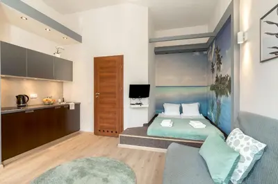 a small room with a bed and a kitchen at Enios Apartments Długa 60 in Kraków