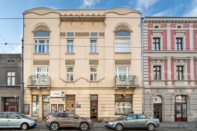 a large building with cars parked in front of it at Enios Apartments Długa 60 in Kraków