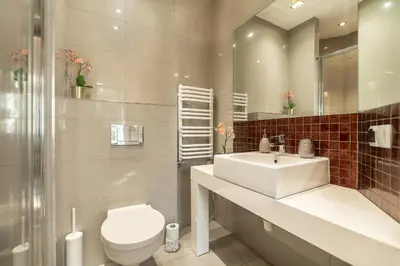 a bathroom with a sink and a toilet and a mirror at Enios Apartments Długa 60 in Kraków