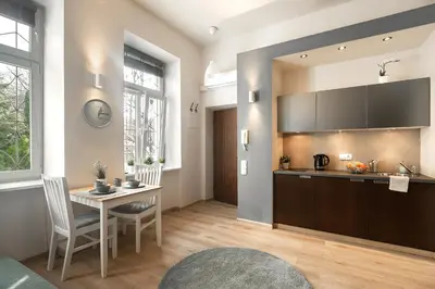 a kitchen and dining room with a table and a counter at Enios Apartments Długa 60 in Kraków