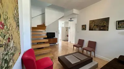 a living room with stairs and chairs and a television at Two Bedrooms City Center Krakow in Kraków