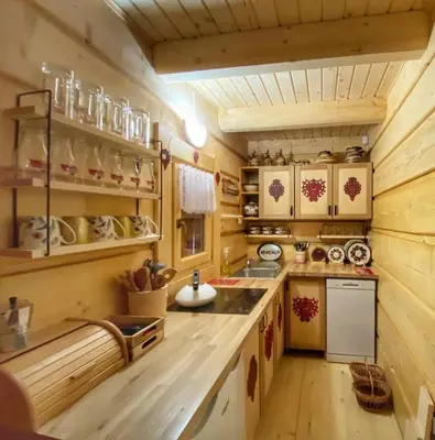 a small kitchen with wooden walls and a wooden floor at CypiSówka in Nowy Targ