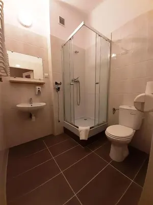 a bathroom with a shower and a toilet and a sink at Red Carpet Hostel in Kraków