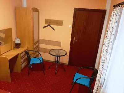 a room with two chairs and a table and a door at Red Carpet Hostel in Kraków