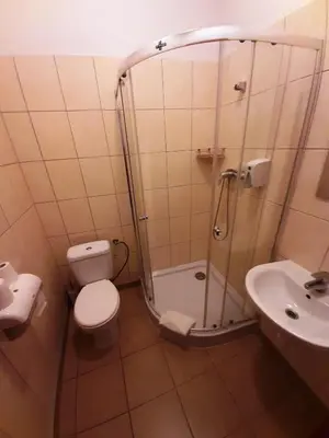 a bathroom with a shower and a toilet and a sink at Red Carpet Hostel in Kraków