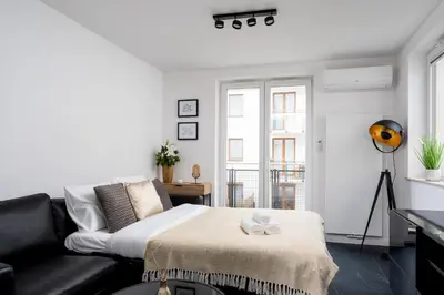 a living room with a bed and a black couch at Apartments Deluxe Barcelona 55 by BookingHost in Kraków