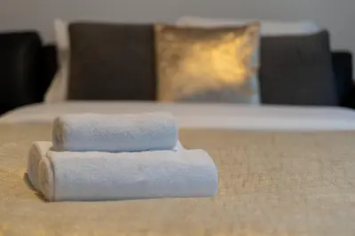 two towels sitting on top of a bed at Apartments Deluxe Barcelona 55 by BookingHost in Kraków
