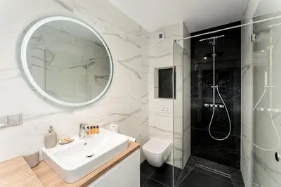 a bathroom with a shower and a sink and a mirror at Apartments Deluxe Barcelona 55 by BookingHost in Kraków