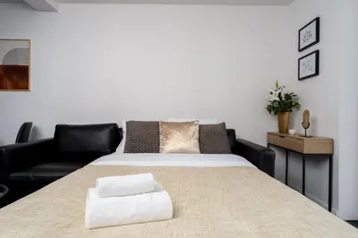 a bedroom with a large bed with a black couch at Apartments Deluxe Barcelona 55 by BookingHost in Kraków