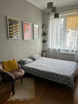 a bedroom with a bed and a chair and a window at KR apartment in Kraków