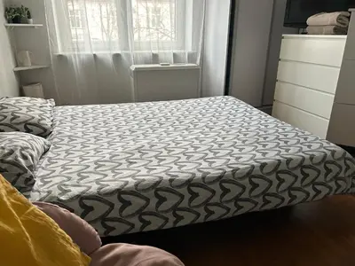 a small bedroom with a bed with a black and white comforter at KR apartment in Kraków