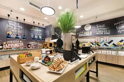 a fast food restaurant with a counter with food at Hampton by Hilton Krakow in Kraków