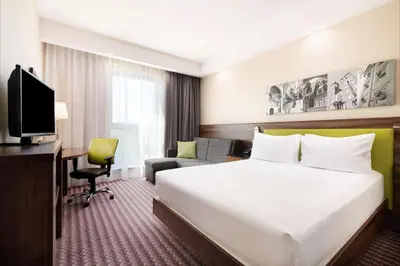 a hotel room with a large bed and a television at Hampton by Hilton Krakow in Kraków
