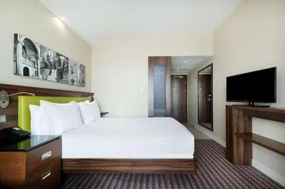 a hotel room with a bed and a flat screen tv at Hampton by Hilton Krakow in Kraków