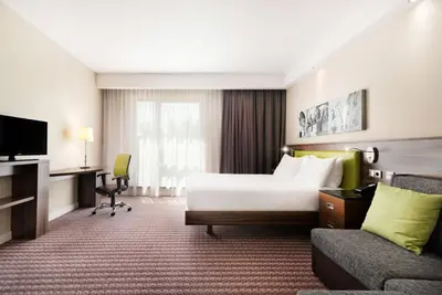 a hotel room with a bed and a couch at Hampton by Hilton Krakow in Kraków