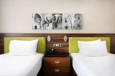 two beds sitting next to each other in a room at Hampton by Hilton Krakow in Kraków