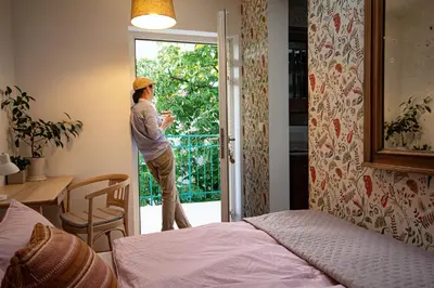 a person standing outside a door looking out of a bedroom at Yesblisko in Kraków