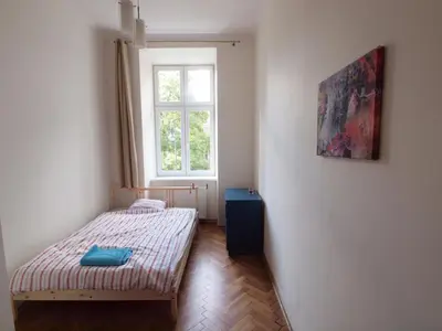 a small bedroom with a bed and a window at Wieża Babel in Kraków