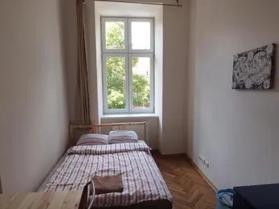a small bedroom with a bed and a window at Wieża Babel in Kraków