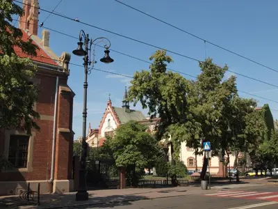 a street light on a city street with buildings at Wieża Babel in Kraków