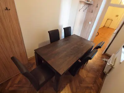 a wooden table with black chairs in a room at Wieża Babel in Kraków