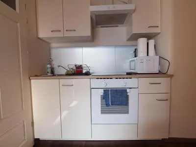 a kitchen with white cabinets and a white stove top oven at Wieża Babel in Kraków