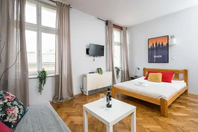 a small room with a bed and a table at Horizon Apartments - Dom Sapiehy in Kraków