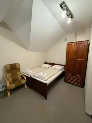 a small room with a bed and a chair at Hotel Karpik Zator Graboszyce in Graboszyce