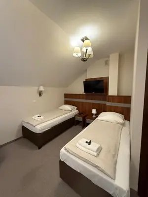 a hotel room with two beds and a tv at Hotel Karpik Zator Graboszyce in Graboszyce