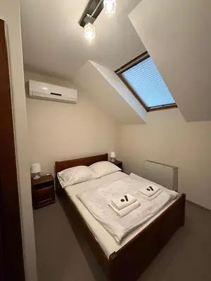 a bedroom with a bed with two towels on it at Hotel Karpik Zator Graboszyce in Graboszyce