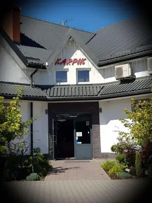 a building with a sign on the front of it at Hotel Karpik Zator Graboszyce in Graboszyce