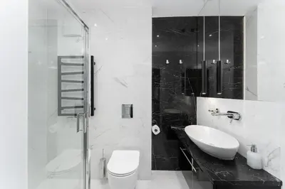 a black and white bathroom with a toilet and a sink at Main Station Stay in Kraków