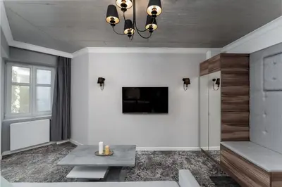 a living room with a tv on a wall at Main Station Stay in Kraków