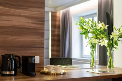 a wooden table with a vase of flowers on it at Main Station Stay in Kraków