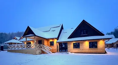 a log house with snow on the ground at Dzika Dziura z jacuzzi in Zawoja
