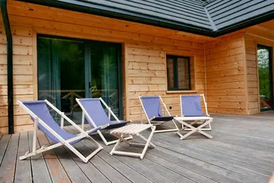 two lounge chairs on a porch of a cabin at Dzika Dziura z jacuzzi in Zawoja