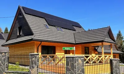 a house with solar panels on top of it at Dzika Dziura z jacuzzi in Zawoja